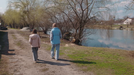 mother and daughter walking by a lake in spring