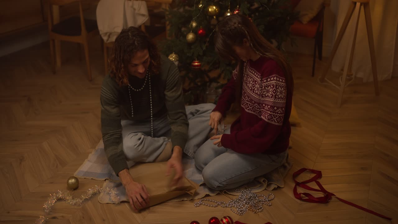 Couple Unwrapping Christmas Gift
