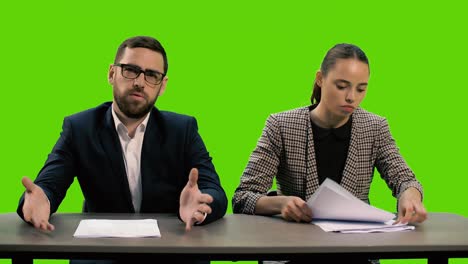 la joven presentadora de televisión hermosa y el joven elegante están presentando un canal de televisión de noticias. la chica se enoja, lanza los papeles y se va. chromakey.