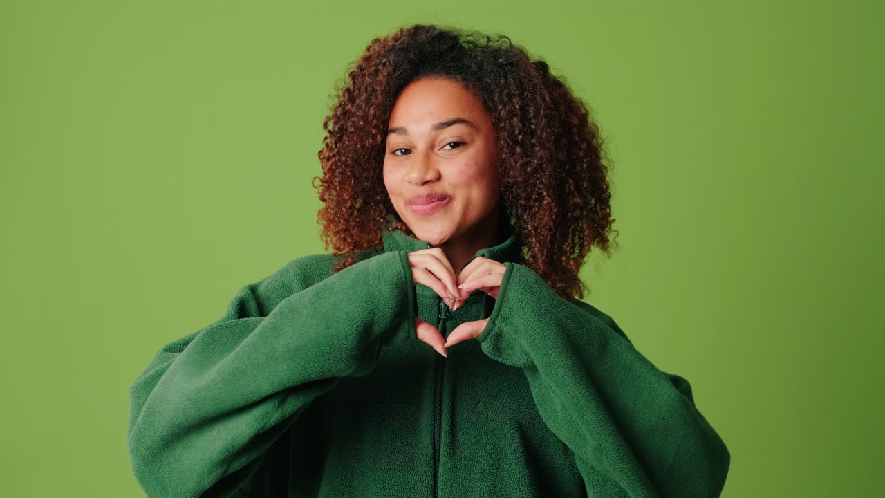 Young African American Woman Making Heart Gesture with Hands and Smiling