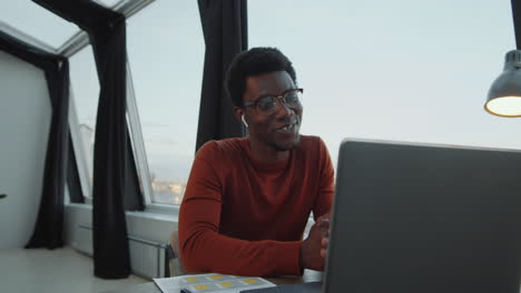 African-American-Businessman-Talking-on-Web-Call-on-Laptop-in-Rooftop-Office