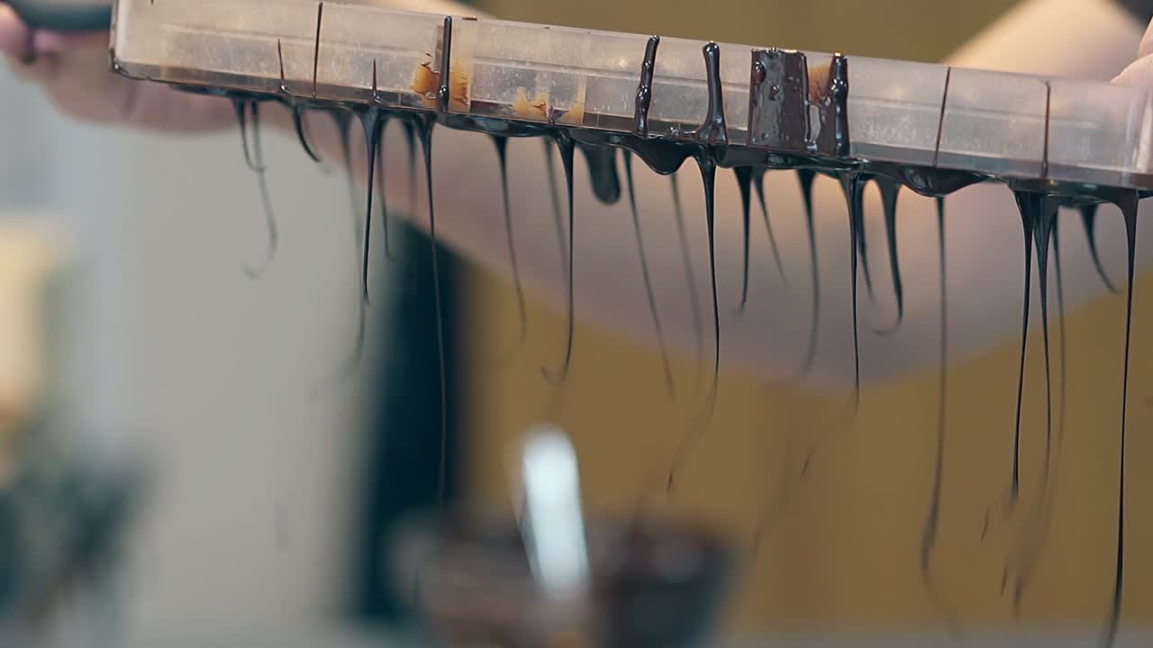 confectioner는 모양에서 어두운 초콜릿 두꺼운 글레이즈를 부어