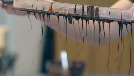 el confitero vierte chocolate oscuro glaseado grueso fuera de forma