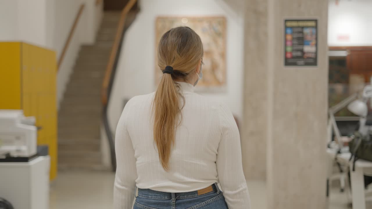 Woman Walking in a Modern Building Corridor