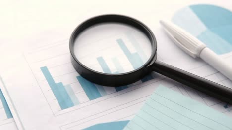 financial data and magnifying glass on blue