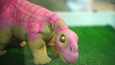 pink toy dinosaur on grass