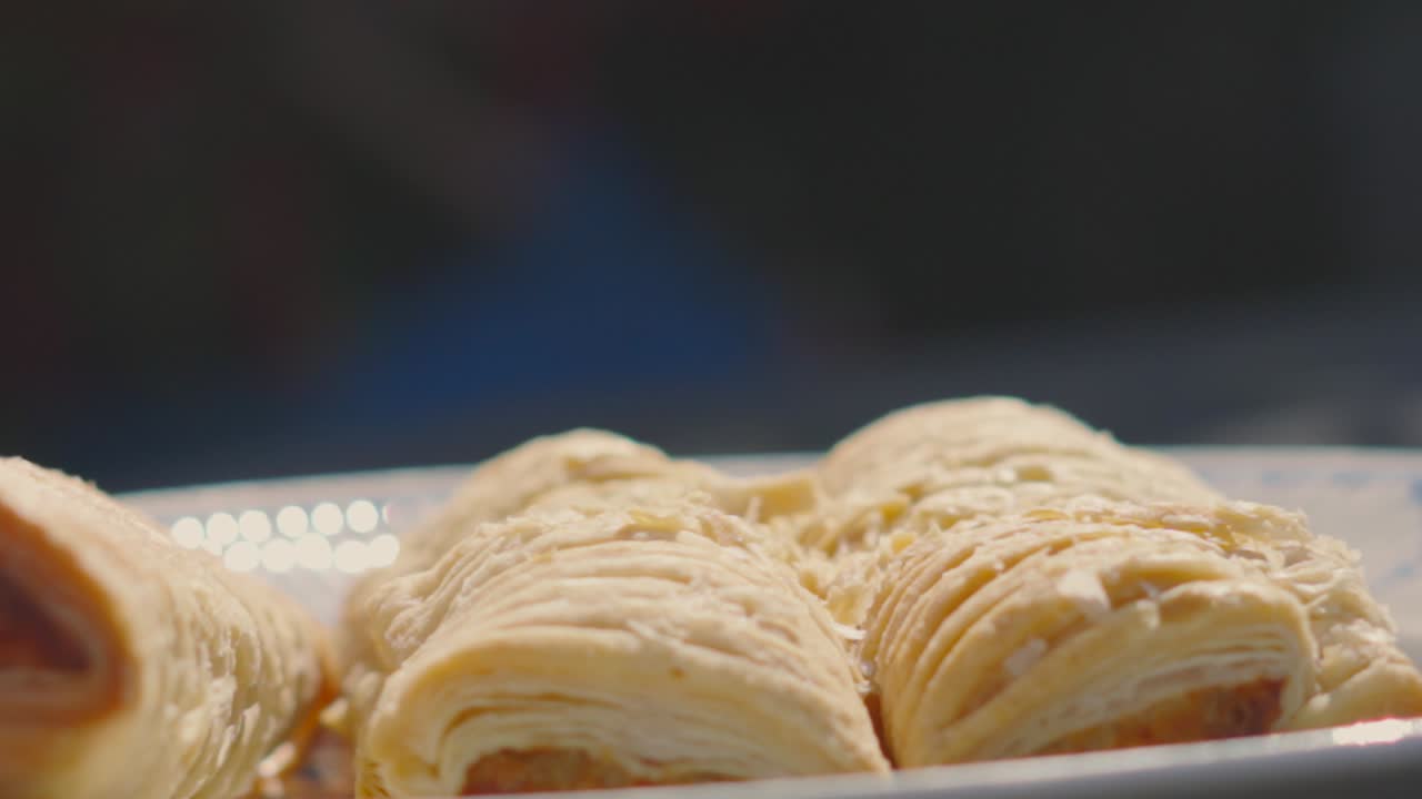 Slow Motion Footage of Sausage Roll Falling Down in Slow Motion with Flakey Pieces of Pastry. Traditional British Fresh Food Delicious Bakery Product. Pork Meat Wrapped in Puff Pastry.
