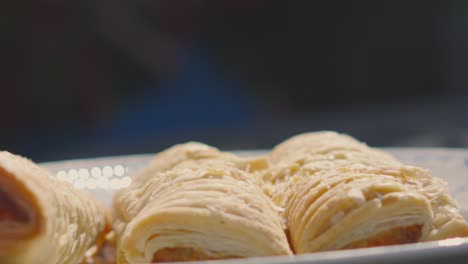 slow motion footage of sausage roll falling down in slow motion with flakey pieces of pastry. traditional british fresh food delicious bakery product. pork meat wrapped in puff pastry.