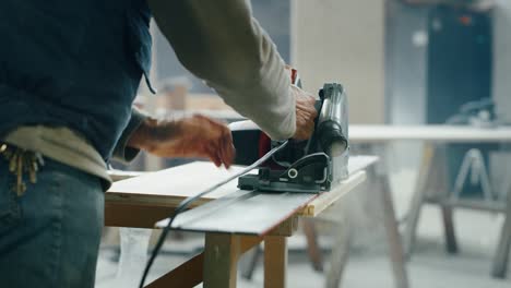 primer plano de un carpintero profesional trabajando en máquinas de carpintería en un taller de una fábrica de madera.