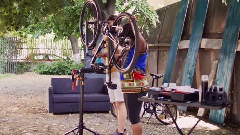 Couple-mounting-bicycle-to-repair-stand