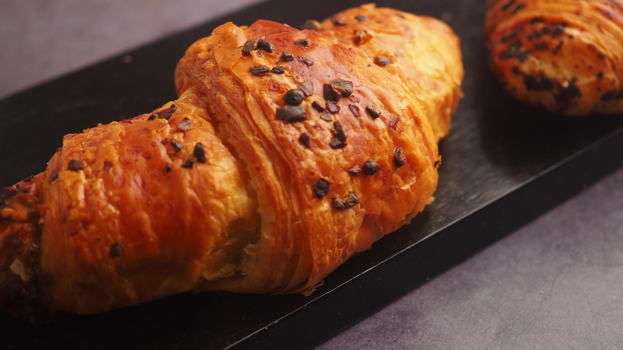 Cornetti al cioccolato appena sfornati su un vassoio da portata nero