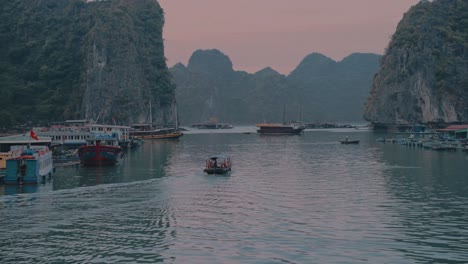 barcos locales navegando en la bahía de lan ha durante la puesta de sol en vietnam
