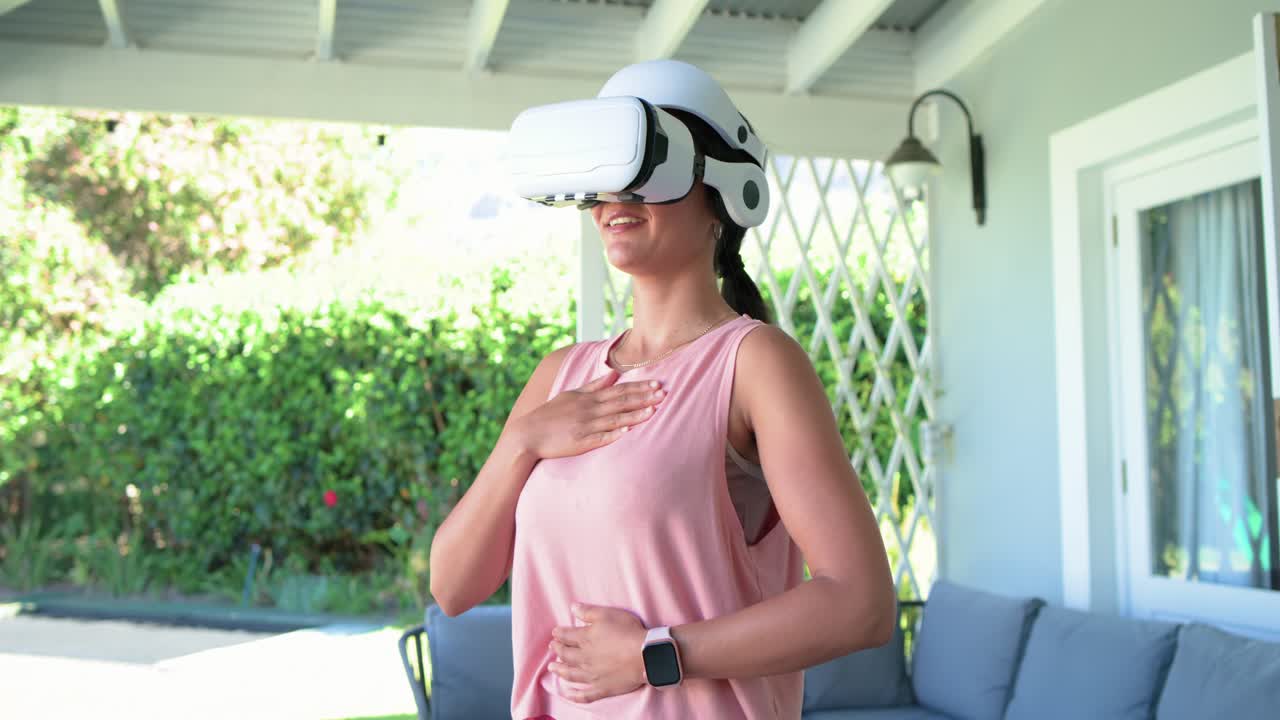 Una donna segue i segnali di respirazione VR per rilassarsi, con le mani sul petto e sull'addome, e si toglie il visore nel patio.