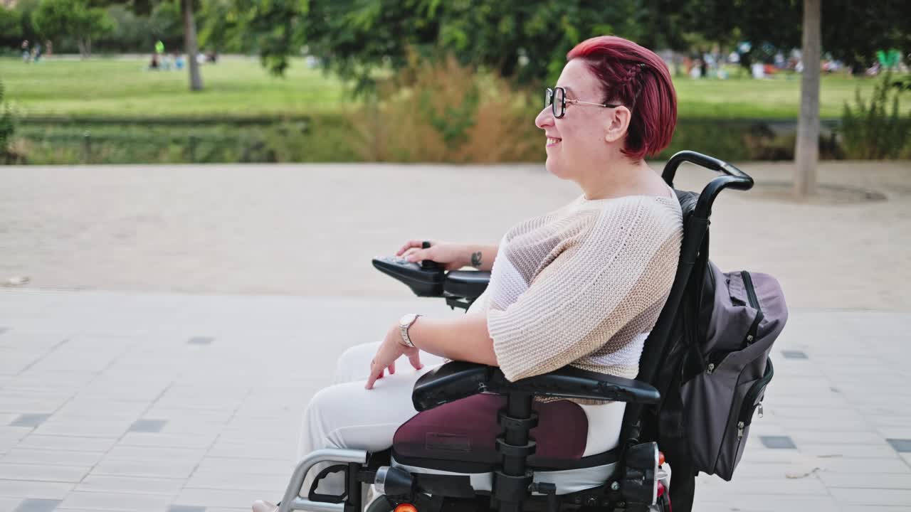 Happy Woman in Electric Wheelchair Moving Through a Park