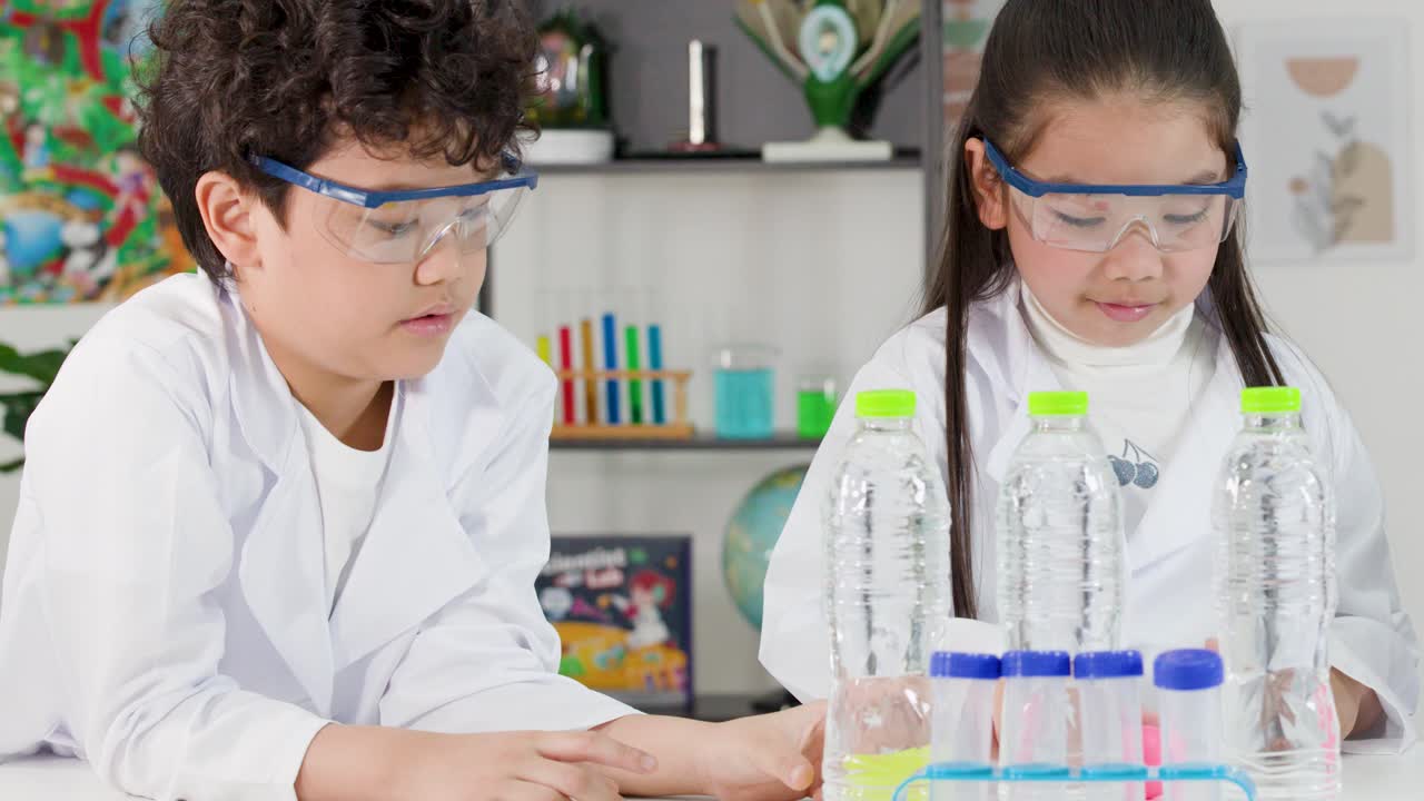 Duas crianças asiáticas em jalecos realizam um experimento de física usando garrafas e pressão do ar