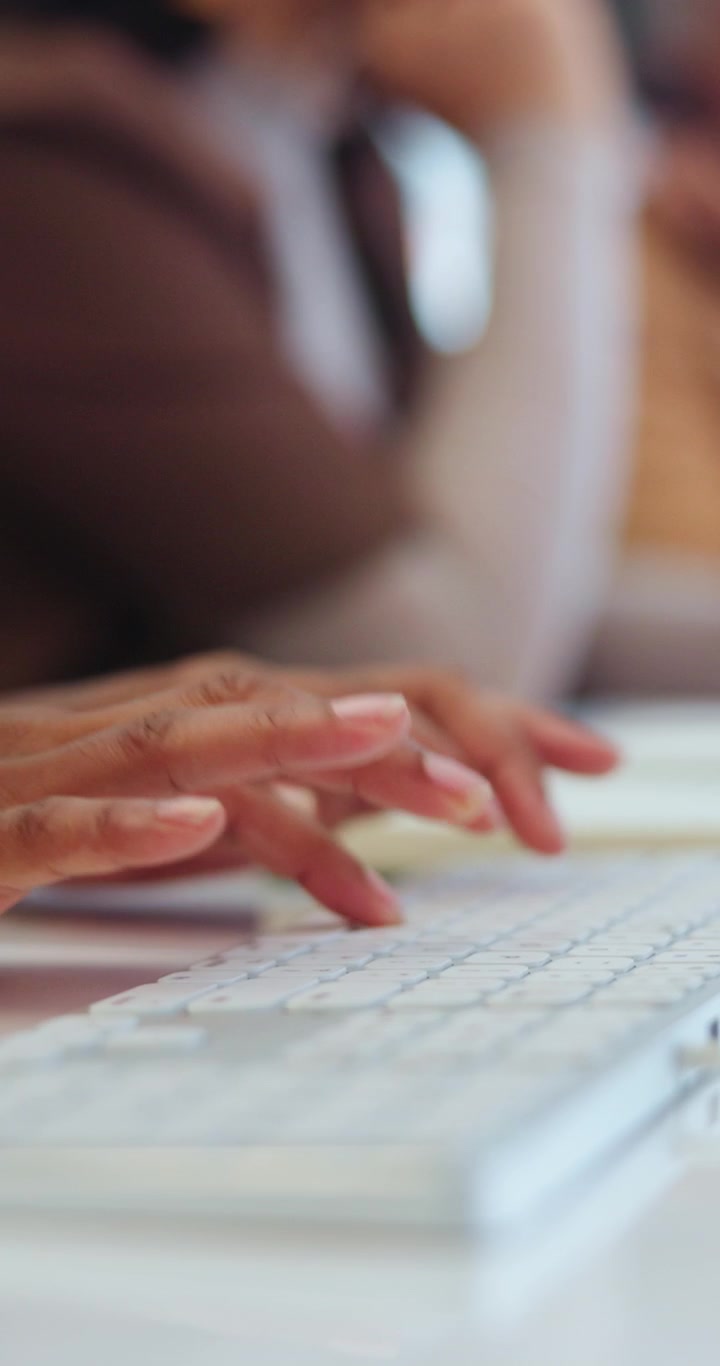 Primo piano di una persona che digita sulla tastiera del computer in ufficio