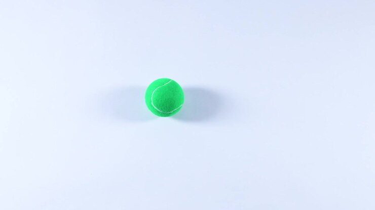 A tennis ball rolls across a flat surface