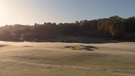 Vuelo-Suave-Y-Tranquilo-De-Drones-Aéreos-Hacia-Atrás-En-Una-Tarde-Soleada-En-Un-Campo-De-Golf-En-Kallered,-Molndal-En-Suecia