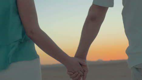 Man-and-woman-take-hands-on-the-beach