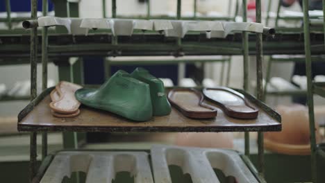 varias etapas de ensamblaje de sandalias en un estante de fábrica