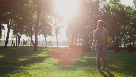 Joyful-man-calling-dog-to-come-back-in-summer-city-garden.-Hand-tapping-on-leg