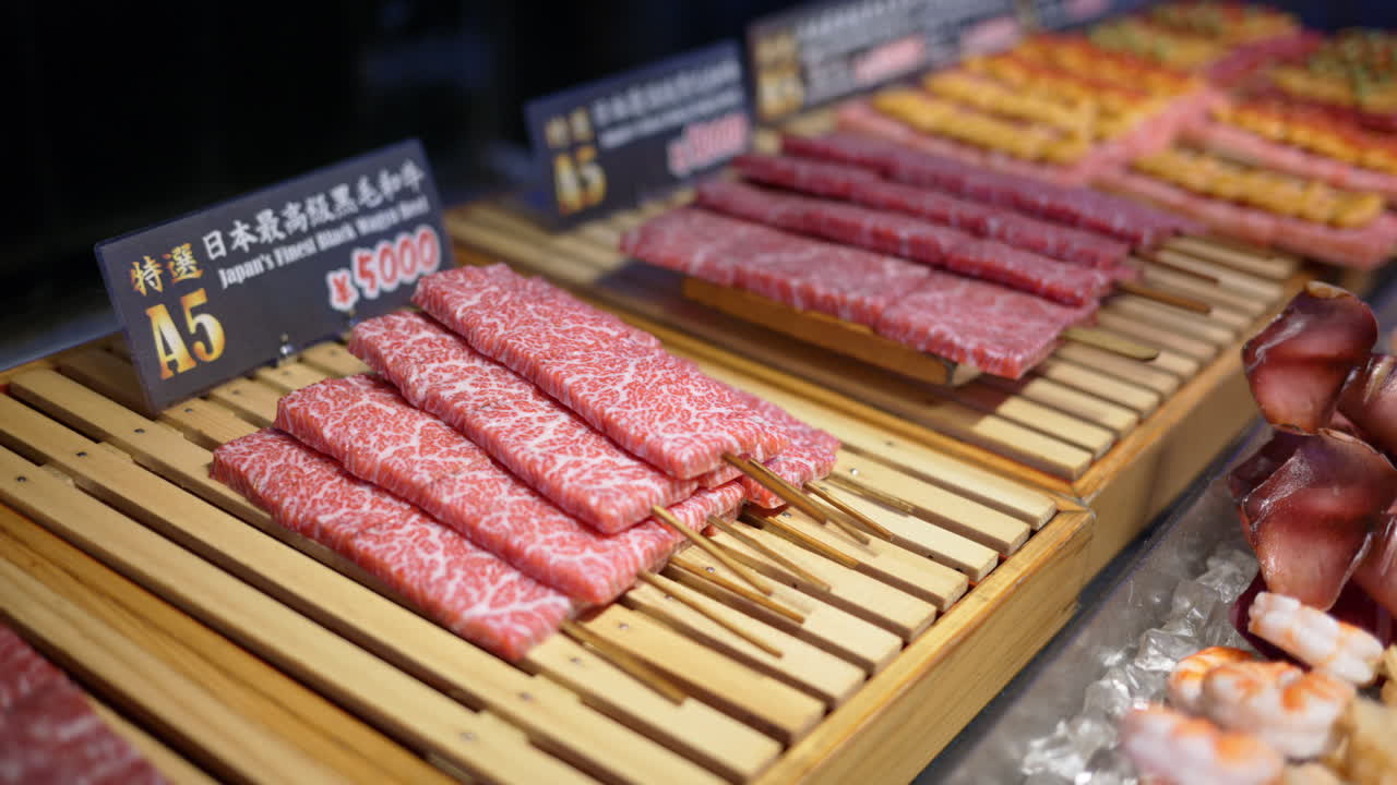 Close up of multiple pieces of Wagyu beef on a wooden tray at the Tsukiji Fish Market in Tokyo, Japan