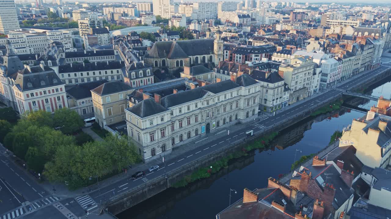 Aerial drone view of the Museum of Fine Arts in Rennes, France. The historic building stands along the banks of the Vilaine River, surrounded by city architecture and bridges