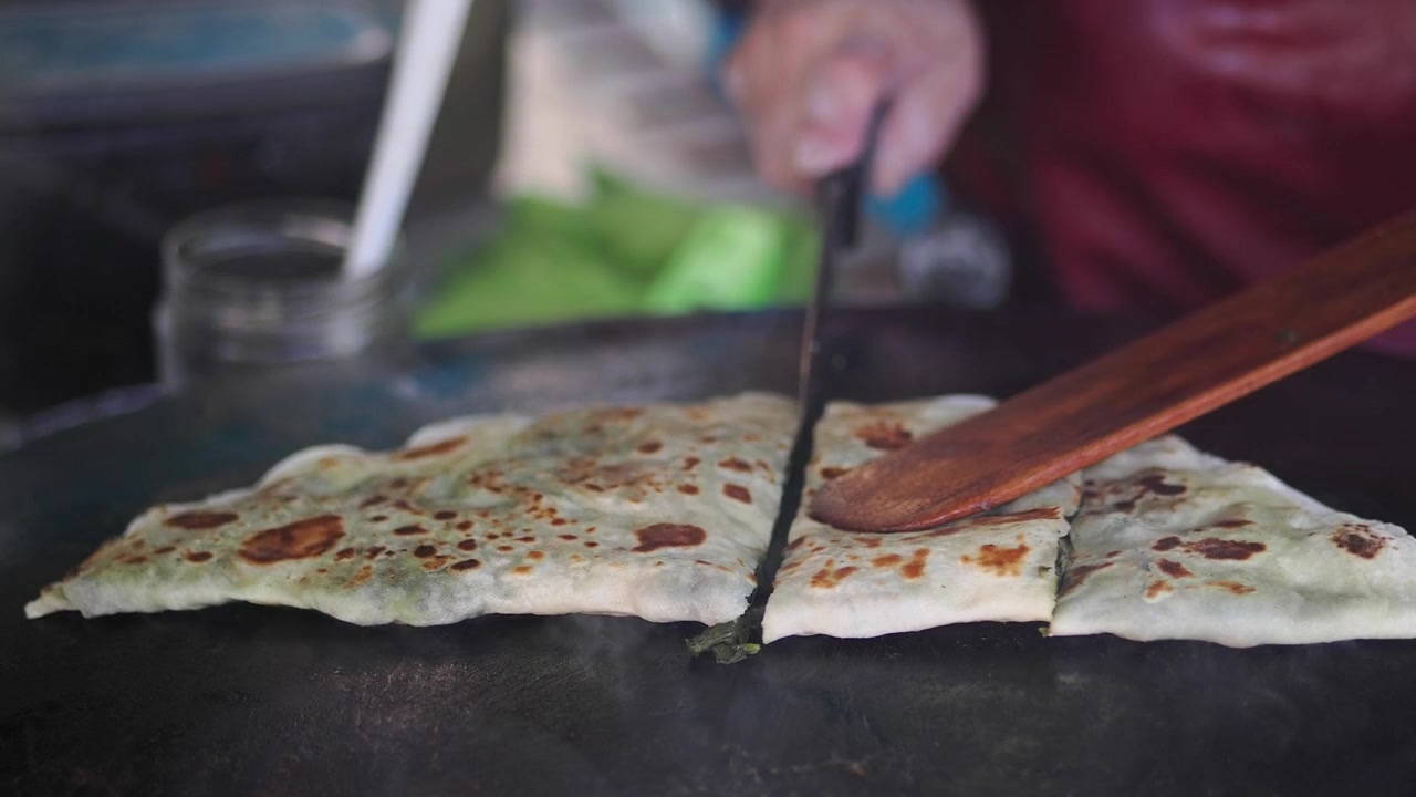 Street Food Vendor Slicing Freshly Cooked Gozleme on Griddle