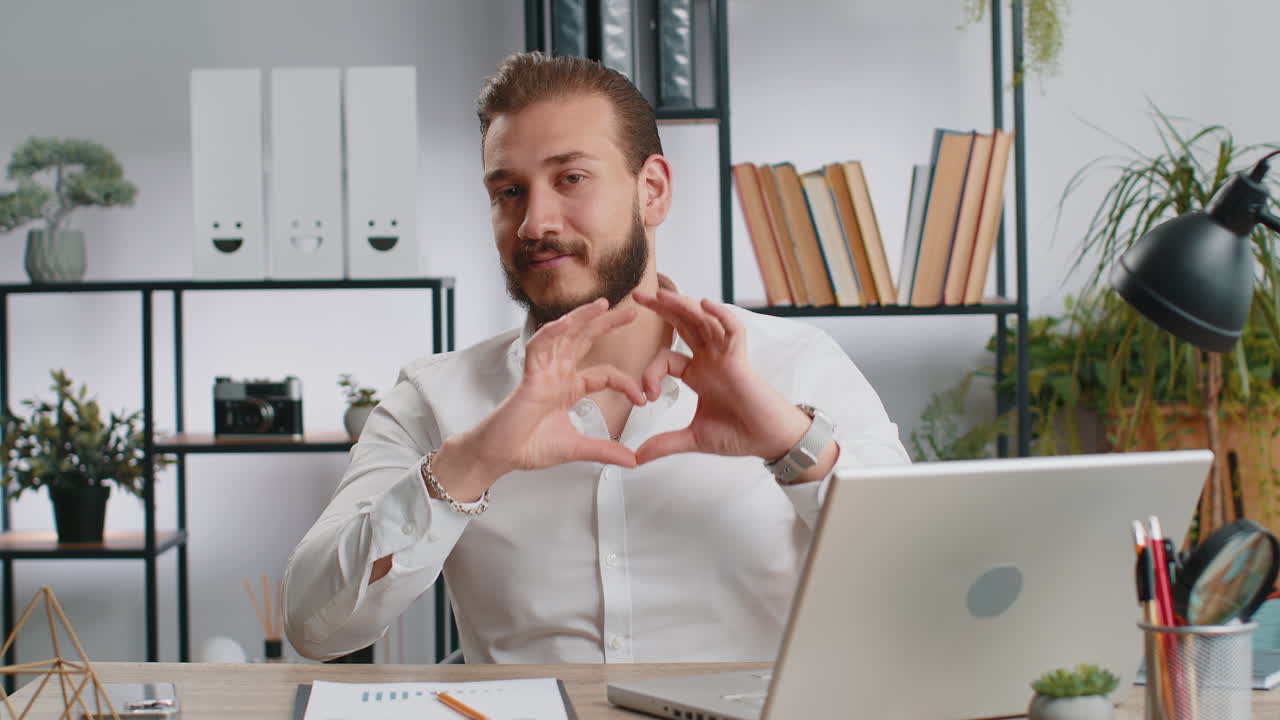 Lebanese business man makes symbol of love showing heart sign to camera express romantic feelings
