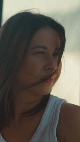 dreaming woman with messy hair rides motorboat at sea cruise. calm lady sits in salon of sailing yacht on summer vacation. passenger on boat board