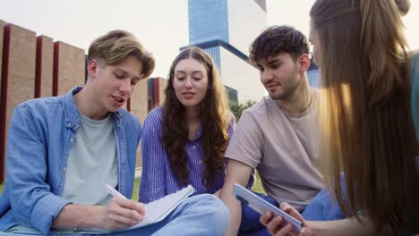 grupo de estudiantes caucásicos que estudian fuera del campus universitario