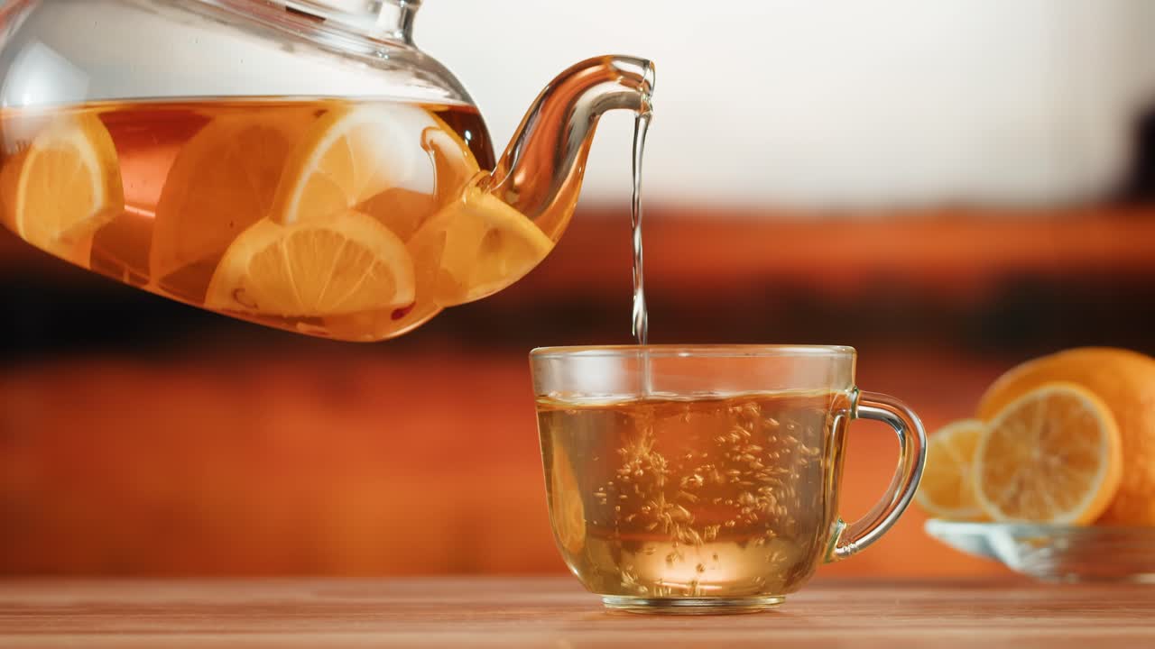 Pouring Hot Lemon Tea into a Glass Cup