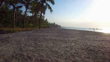 tiro estable de la perspectiva del camino en la playa en la isla de nusa penida en la puesta de sol cerca de las palmeras