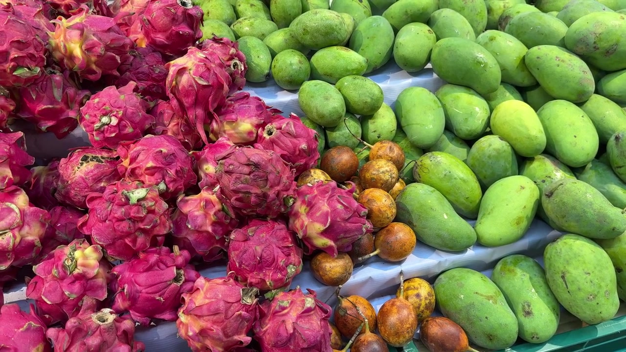 Esposizione colorata di frutto del drago, manghi e frutto della passione in un negozio