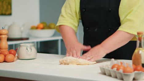 woman hands kneading dough on table