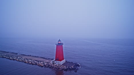 red lighthouse in foggy lake at dusk