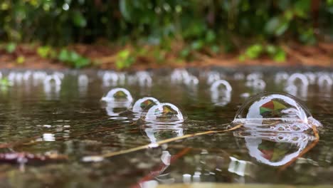 Eine-Pfütze-Aus-Klarem-Regenwasser-Und-Langsam-Schwebenden-Regenblasen