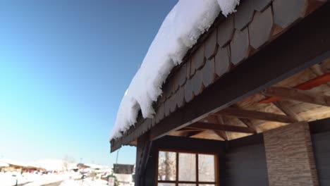 Inclinar-Hacia-Abajo-Vista-Detallada-De-La-Nieve-Sobre-Un-Techo-De-Madera-De-Una-Parada-De-Autobús-En-El-Pueblo-De-Montaña-De-Farellones,-Chile