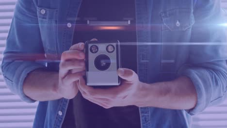 rastros de luz contra la sección media del fotógrafo masculino que sostiene una cámara retro