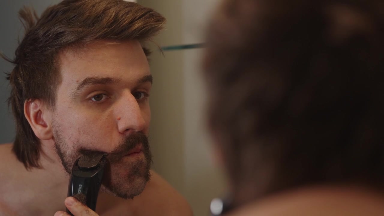 Toma por encima del hombro de un hombre afeitándose en el espejo (4k60p)