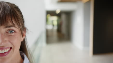 smiling woman in office hallway, close-up of face with blurred background, copy space