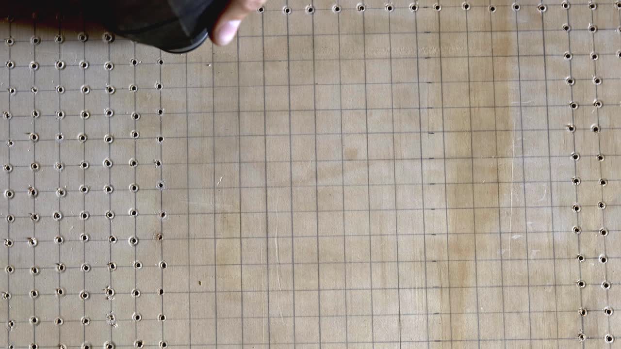 perforar un patrón de agujeros usando una herramienta eléctrica y guiado por líneas de cuadrícula