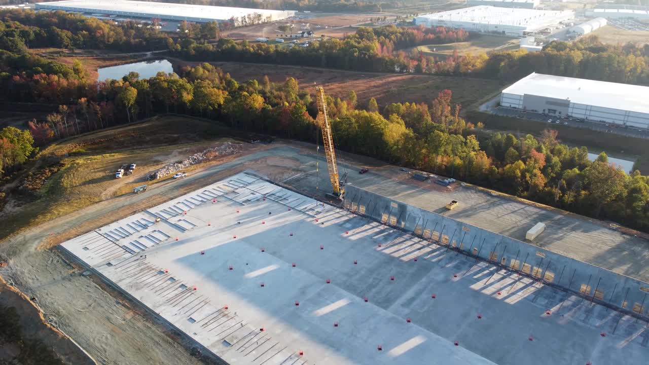 una toma en órbita de hombres sujetando un panel de concreto a una grúa de servicio pesado