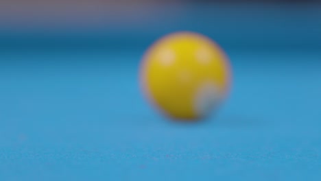 close up of hitting pool ball on blue billiards table - fast