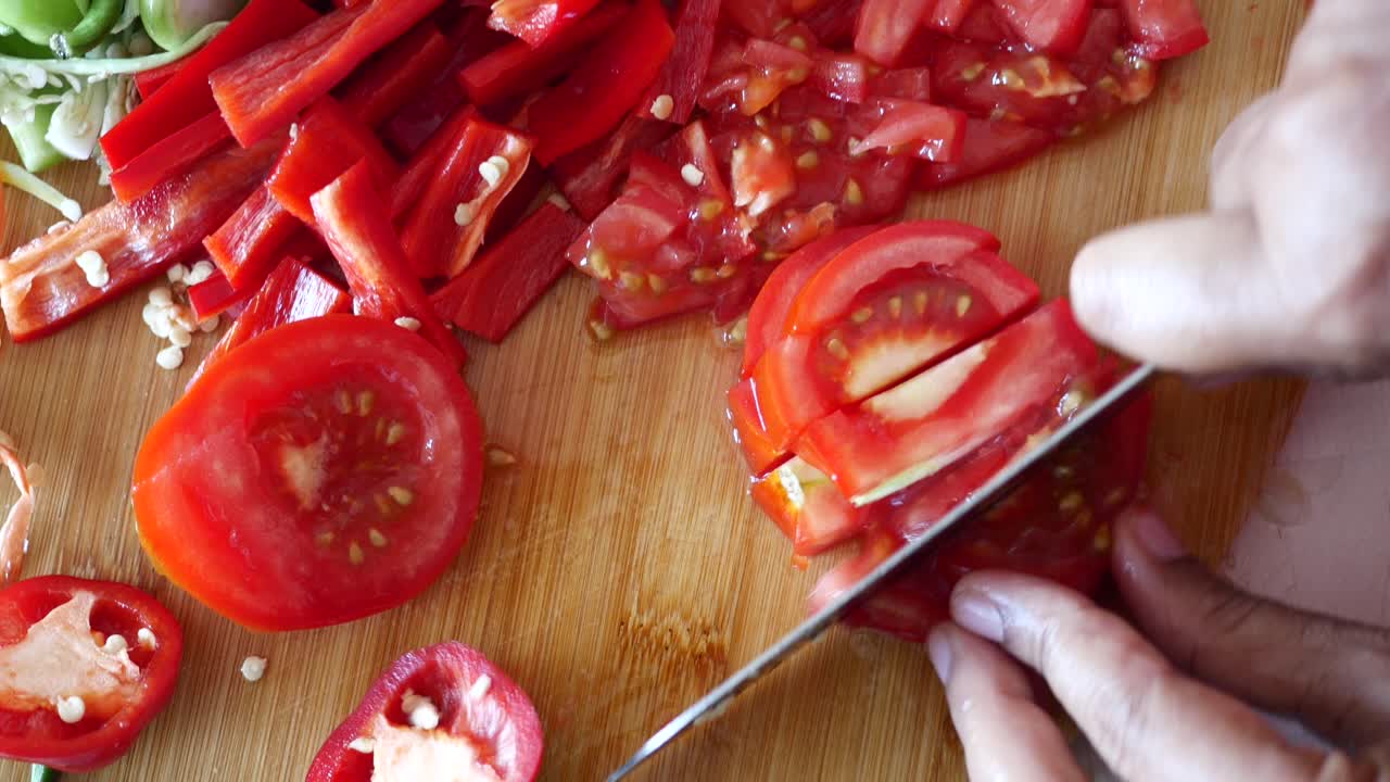 cortar pimientos rojos y tomates para cocinar
