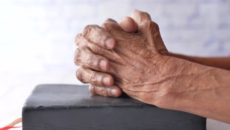 senior women holding a bible in his hands and praying