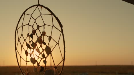 native american dreamcatcher hanging in breeze at sunset