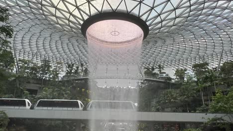 singapore jewel indoor waterfall vortex at changi airport - side view monorail train passing 3 carriages