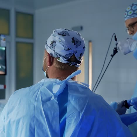 professional surgery in modern operating room. team of doctors perform an operation to a patient and and look on the monitor during surgical process.