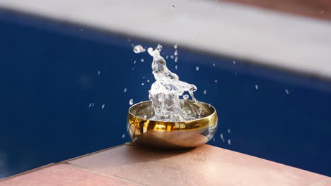 slow motion of water drops into the bowl and splashes